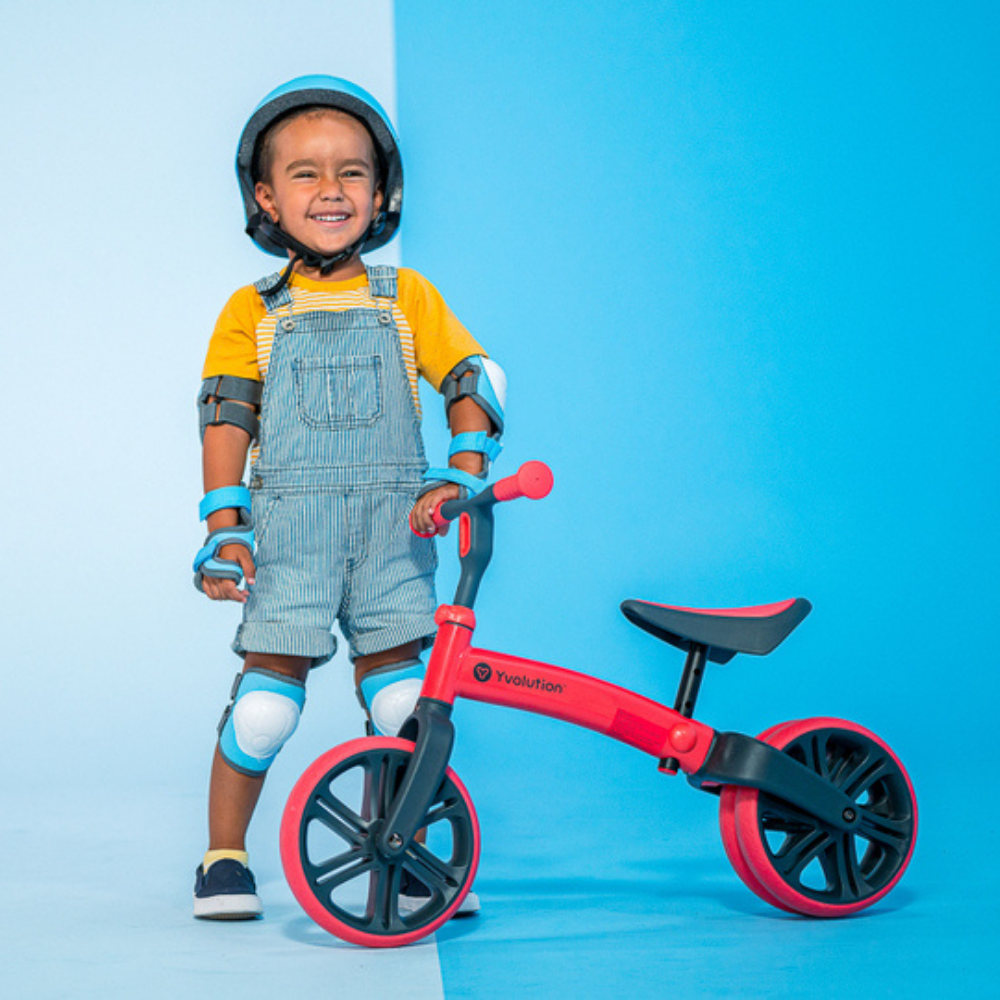 Child with a balance bike on a blue background