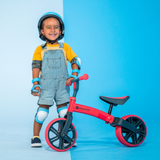 Child with a balance bike on a blue background