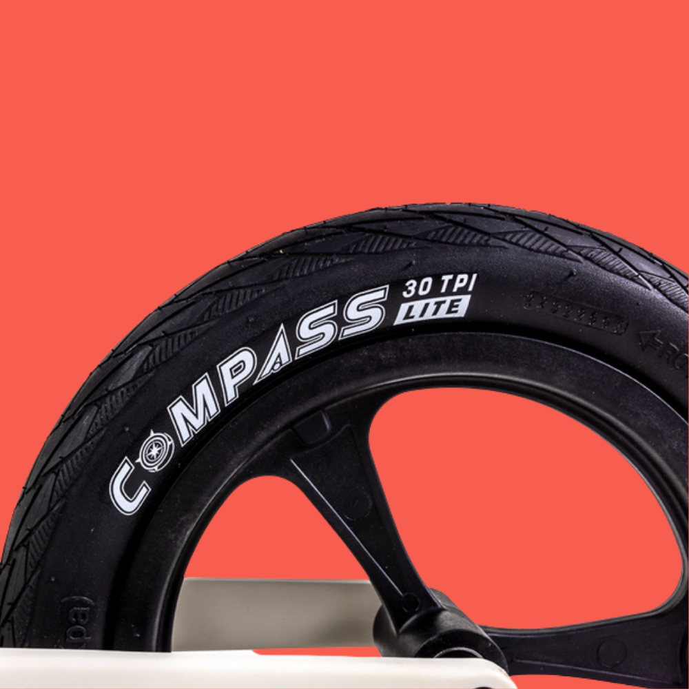 Black tire with 'Compass' branding on a red background