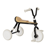 Children's tricycle with black frame and white wheels on a white background