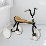 Modern children's tricycle with wooden seat on a white floor