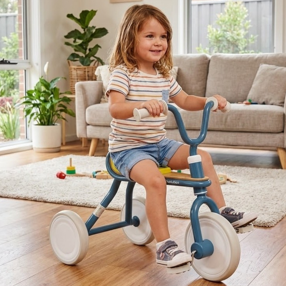 Child riding a tricycle in a living room with plants and furniture.