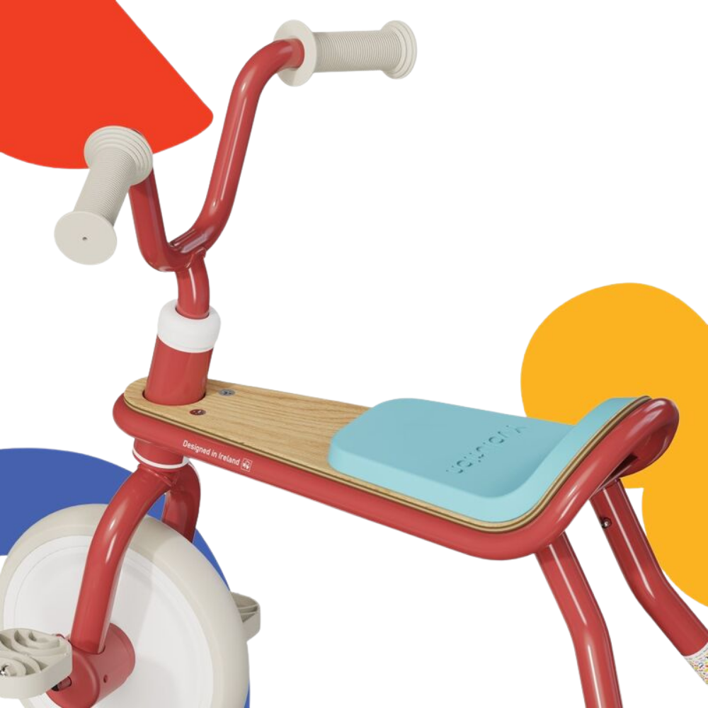 Children's tricycle with red frame, blue seat, and colorful wheels on a white background