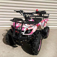 A pink 49cc petrol-powered 2-stroke farm-style quad bike for kids with knobby tyres and a steel grill tray at the rear.
